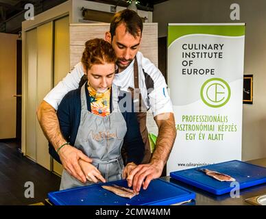 Come si raccorda una trota? Laszlo Papdi spiega la tecnica di taglio in cucina durante un corso presso l'Istituto culinario di Budapest, Ungheria Foto Stock