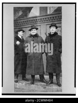 John McCormack, irlandese-americano nato il tenore di intera lunghezza verticale, rivolto verso la parte anteriore, in piedi con due uomini sui gradini fuori dall'edificio Foto Stock