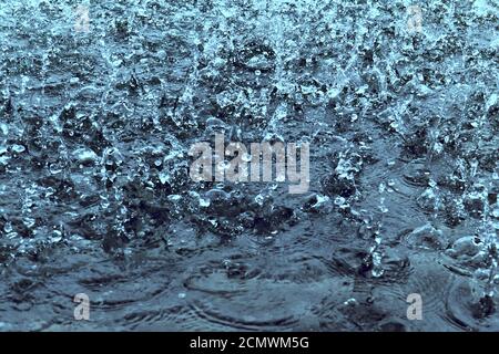 Gocce di pioggia su acqua come sfondo Foto Stock