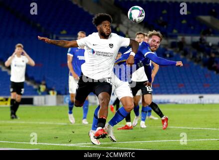 Ellis Harrison di Portsmouth (a sinistra) e Alexis Mac Allister di Brighton e Hove Albion si battono per la palla durante la seconda partita della Carabao Cup all'AMEX Stadium di Brighton. Foto Stock