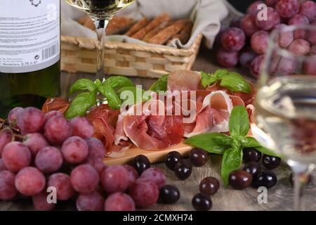 Antipasto. Set vino snack sun-prosciutto jamon con uve e olive Foto Stock