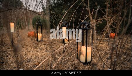 Lanterne e candele illuminano la strada. Asciuga il pennello alto e gli alberi in un canyon appartato al tramonto Foto Stock