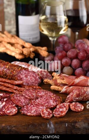 Antipasto. Piatto con salsiccia, prosciutto secco, salame, grissini croccanti con uva. Un antipasto di carne è un Foto Stock