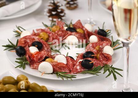 Corona di Natale - antipasto. Tartine di salame con olive, mozzarella. Foto Stock