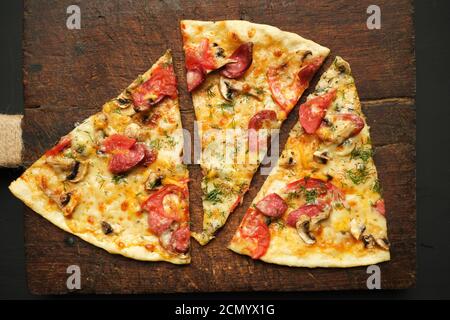 pizza cotta con salsicce affumicate, funghi, pomodori, formaggio e aneto Foto Stock