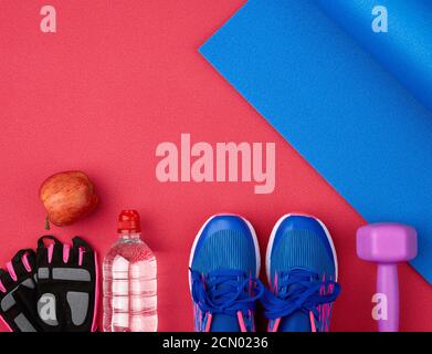 paio di sneaker blu da training con lacci, bottiglia d'acqua e tappetino in neoprene intrecciato blu Foto Stock
