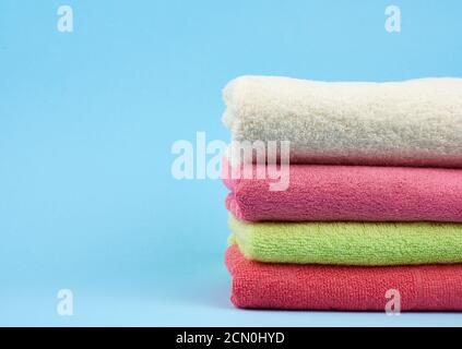 stack di asciugamani piegati in spugna di cotone colorato su un blu sfondo Foto Stock