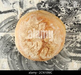 pane tostato e farina di grano bianco sparsi su un tavolo nero Foto Stock