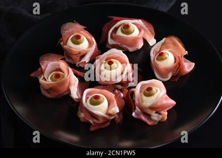 Halloween originali snack. Bulbi oculari cucinato da prosciutto con mozzarella di bufala, Olive farcite con peperone rosso Foto Stock