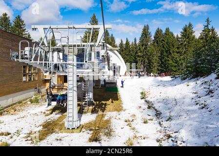 Piste da sci innevate e stazione di skilift per seggiovie in località sciistica di montagna. Foto Stock