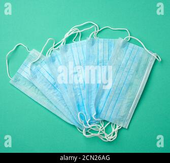 stack di maschere mediche blu monouso su sfondo verde Foto Stock