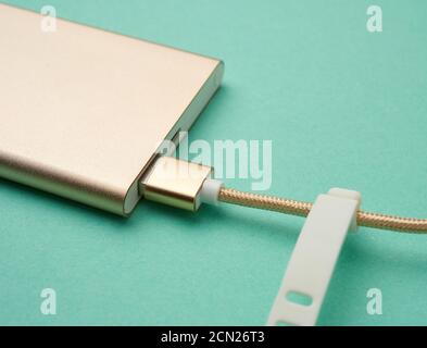 power bank e cavo golden con connettore usb per ricarica dei dispositivi mobili Foto Stock