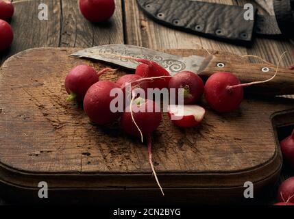 ravanello rosso rotondo su una tavola da cucina vintage Foto Stock