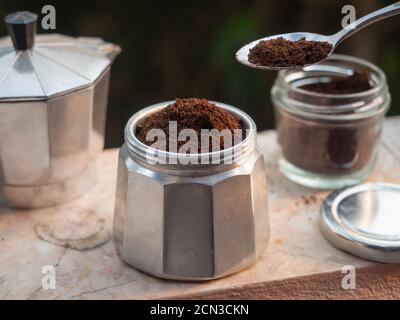 Mettere il caffè macinato in una pentola di moka Foto Stock