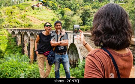 donna che scattava una foto dei suoi amici all'iconico Ponte Nine Arch Foto Stock