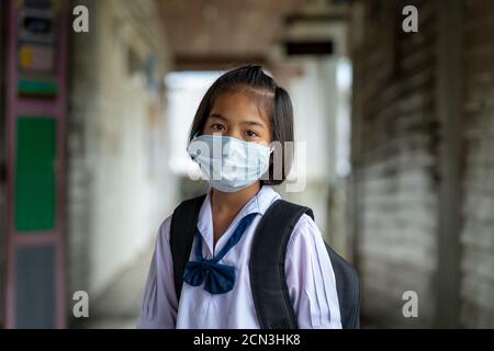 Studenti asiatici indossare maschera protettiva per proteggere contro Covid-19, ritorno a scuola riaprire la loro scuola, istruzione, scuola elementare.
