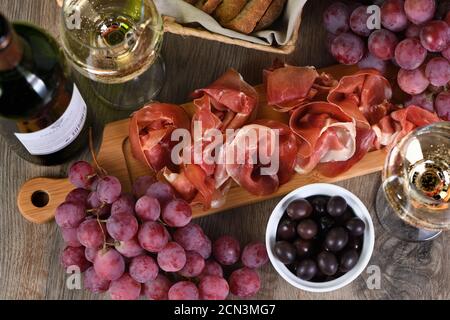 Antipasto. Set vino snack sun-prosciutto jamon con uve e olive Foto Stock