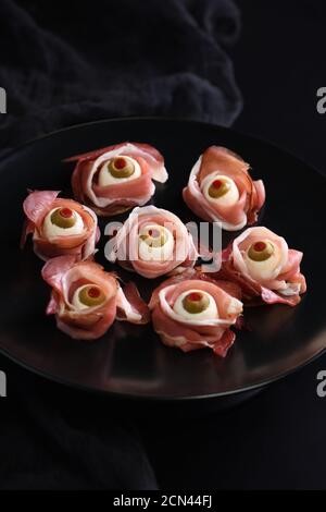 Halloween originali snack. Bulbi oculari cucinato da prosciutto con mozzarella di bufala, Olive farcite con peperone rosso Foto Stock