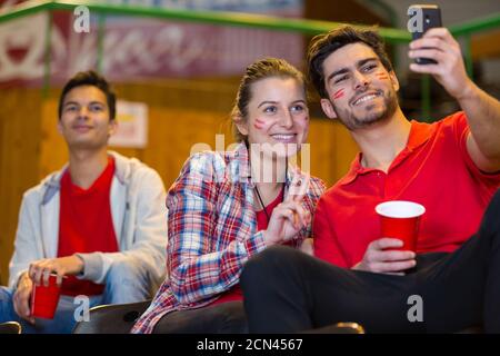 tifosi sportivi che prendono selfie nei stand Foto Stock