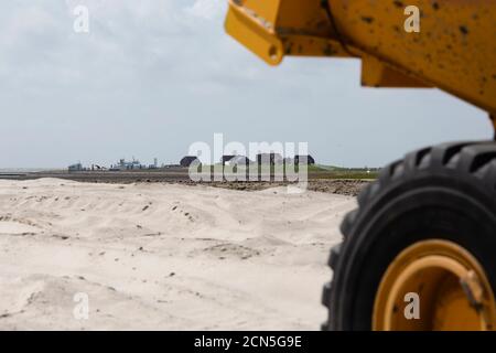 29 luglio 2020, Schleswig-Holstein, Langeneß: Il porto dei traghetti dell'Hallig Langeneß è visibile dal cantiere navale di Treuberg. 73000 metri cubi di sabbia sono necessari qui per il riempimento per costruire appartamenti, una stazione di cura e un supermercato. (Per 'costruito sulla sabbia: Su Hallig Langeneß un nuovo cantiere sta crescendo faticosamente') Foto: Frank Molter/dpa Foto Stock