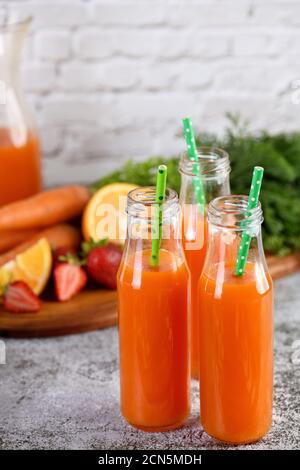 Disintossicare la bevanda. Succo di arancia di fragola di carota appena fatto. Per coloro che controllano la loro salute Foto Stock