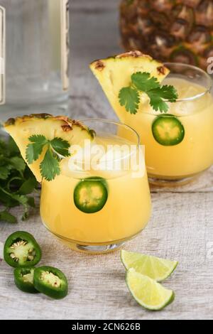 Tequila cocktail con succo di ananas, jalapeno fette e coriandolo, raffreddato con ghiaccio Foto Stock