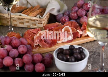 Antipasto. Set vino snack sun-prosciutto jamon con uve e olive Foto Stock