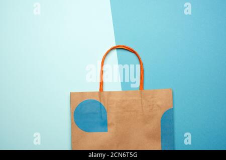 sacchetto di carta marrone con maniglie per lo shopping su sfondo blu, piatto Foto Stock