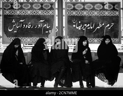 Mashhad, Iran - Febbraio 14,2008 : Mashhad è la seconda città più grande in Iran.Mashhad è una città Santa per Shi'ite Mussulmani.Women in attesa alla fermata dell'autobus. Foto Stock