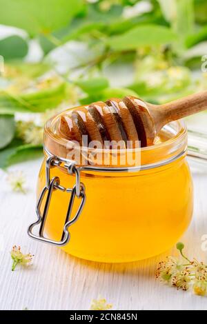 Vasetto di miele di lime con un cucchiaia di legno. Foto Stock