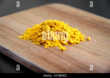 Polvere di spezie curcuma su un tagliere Foto Stock