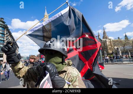 Un dimostratore anti austerità ha una bandiera di anarchia, protestando contro il nuovo governo conservatore e la loro politica di austerità, Parliament Square, Westminster, Londra, Regno Unito. 9 maggio 2015 Foto Stock