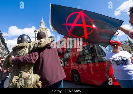 Un dimostratore anti austerità ha una bandiera di anarchia, protestando contro il nuovo governo conservatore e la loro politica di austerità, Parliament Square, Westminster, Londra, Regno Unito. 9 maggio 2015 Foto Stock