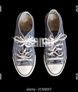 Vecchie sneakers blu isolate su sfondo nero Foto Stock