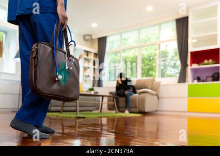 Primo piano del medico asiatico visita paziente a casa Foto Stock