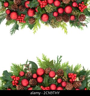 Natale sfondo festivo confine con rosso bauble decorazioni e naturale inverno verde di agrifoglio, edera, mistetoe, coni di pino e foglie di cedro. Foto Stock