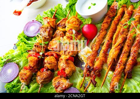 Szaszlyk alla griglia e riares di carne con insalata verde Foto Stock