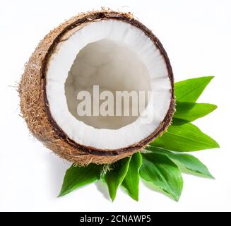 Metà di cocco cracked con polpa bianca su foglie verdi isolate su sfondo bianco. Foto Stock