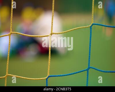 Il giocatore di calcio si contrappone al gol con la rete e lo stadio. Rete porta calcio. Porta di calcio Foto Stock