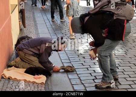 Praga, Repubblica Ceca, 12 ottobre 2019. Un ragazzo che chiacchiera con un migrante che mendicava. Foto Stock