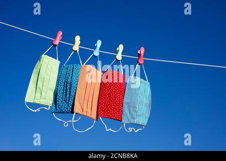 maschere colorate appese su una linea di lavaggio Foto Stock