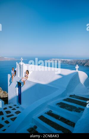 Coppia uomini e donne in vacanza Santorini, vista sul mare e Vulcano da Fira la capitale dell'isola di Santorini in Grecia Foto Stock