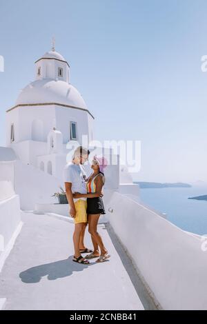 Coppia uomini e donne in vacanza Santorini, vista sul mare e Vulcano da Fira la capitale dell'isola di Santorini in Grecia Foto Stock