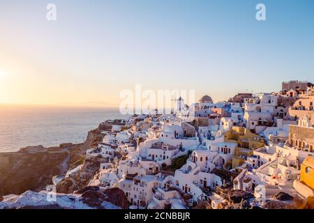 Tramonto sull'isola di Santorini Grecia, bellissimo villaggio bianco Oia con chiesa e mulino a vento durante il tramonto Foto Stock