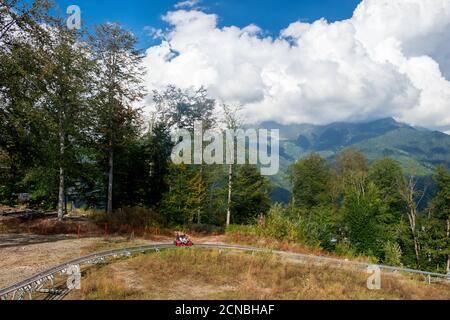 Olympic Village, Krasnaya Polyana, Sochi, Russia - 08 settembre 2020: Rodelbahn giro con le montagne sullo sfondo. Foto Stock