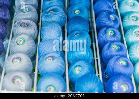 Mosca, Russia - 14 febbraio 2019: Stend di filo per la maglieria in un negozio. Sfondo testtrure colorato Foto Stock