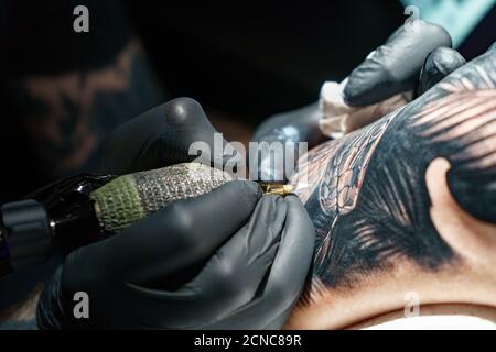 Tattooer facendo tatuaggio nero di serpente per la donna Foto Stock