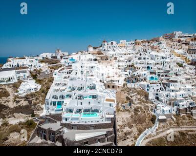 Vista sul drone di Santorini, vista aerea sul villaggio imbiancato di Oia con lussuoso resort per vacanze con piscine infinity in SA Foto Stock