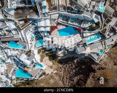 Vista sul drone di Santorini, vista aerea sul villaggio imbiancato di Oia con lussuoso resort per vacanze con piscine infinity in SA Foto Stock