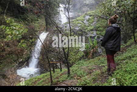 DOI INTHANON NATIONAL PARK, TAIWAN - 03 settembre 2019: Una escursionista femminile si prende nella potente cascata di Mae Pan nascosta nella rurale Doi Inthanon Natia Foto Stock